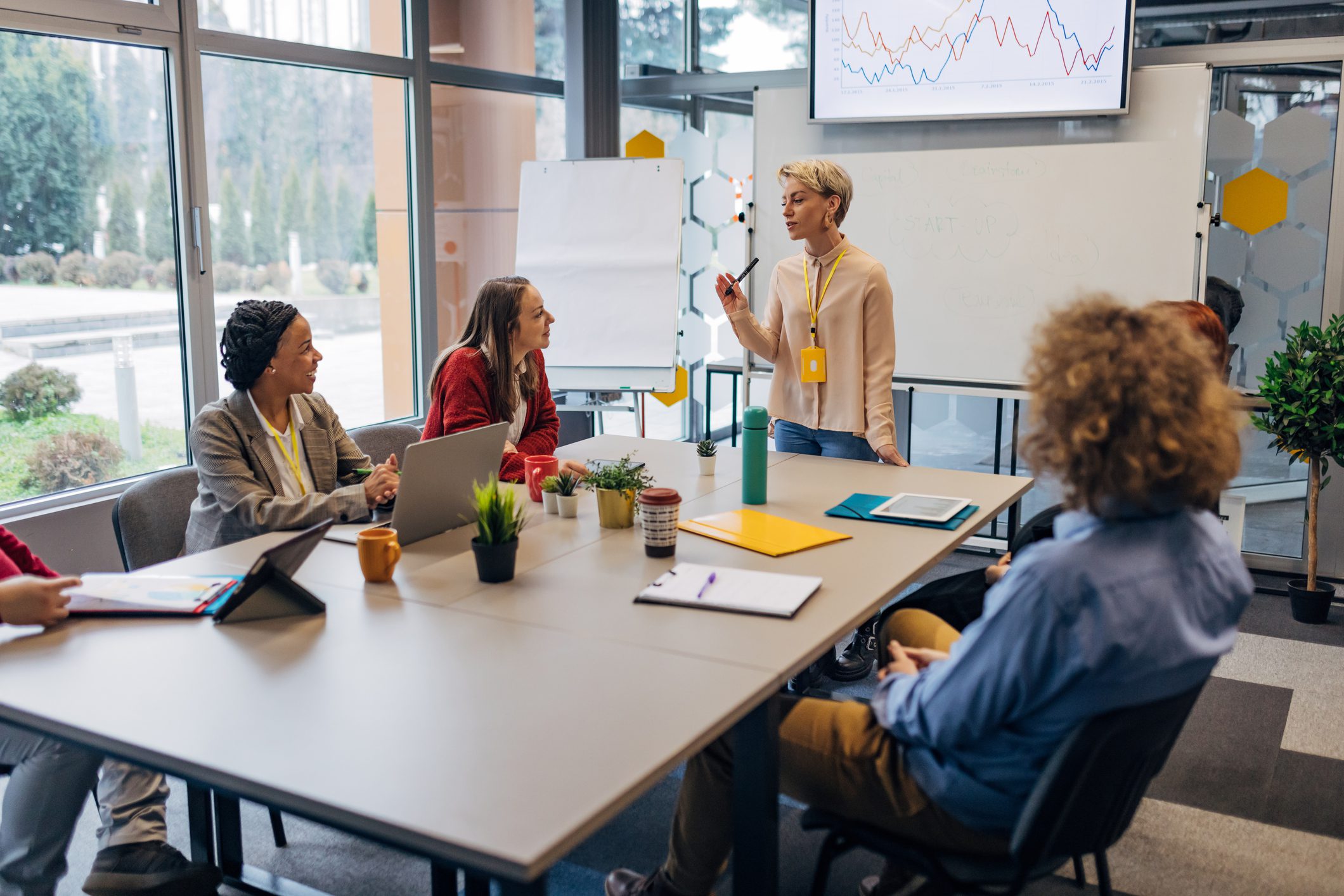 Businesswoman leading a team meeting in a modern office.